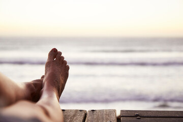 Personal perspective barefoot woman with sand on foot and ocean view