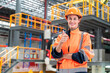 © supAVADEE BUTRADEE - Caucasian female engineer in reflective jacket and safety helmet showing thumbs up and inspecting construction work, steel racks in warehouse using distribution center