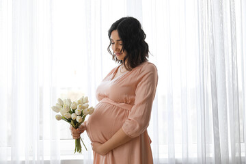 Sticker - Young pregnant woman with tulips near window at home