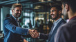 © annebel146 - Two happy mature business men shaking hands in office. Successful african american businessman in formal clothing closing deal with handshake. Multiethnic businessmen shaking hands during a meeting.
