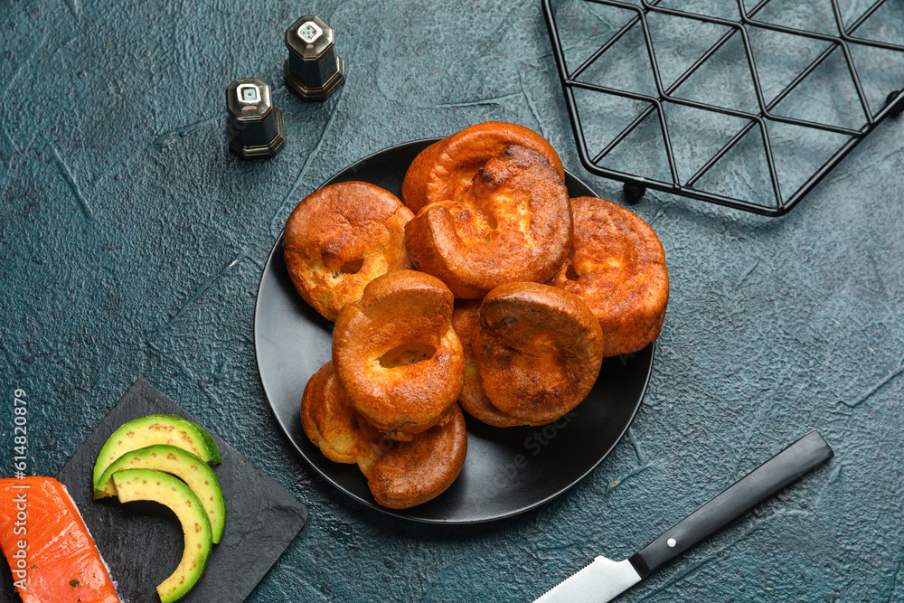 Plate with tasty Yorkshire pudding on blue background