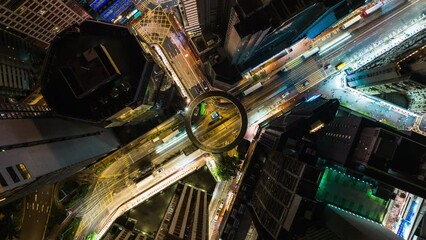 Wall Mural - Hyperlapse time-lapse of car traffic on road junction intersection in Hong Kong city downtown. Drone aerial top view fly up. Asian people lifestyle, Asia night life or public transportation concept