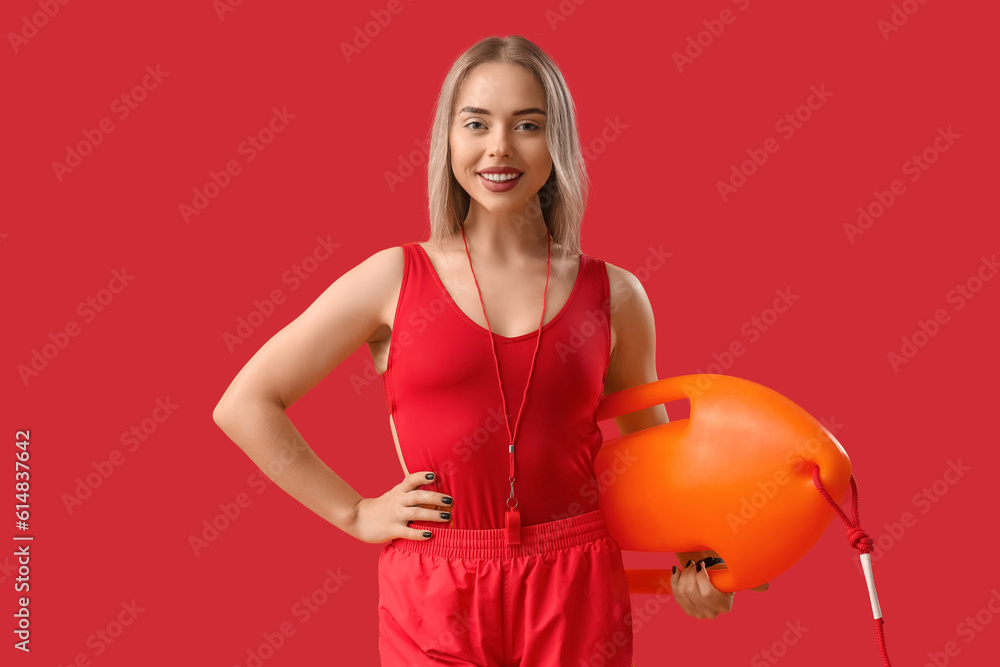 Female lifeguard with rescue buoy on red background