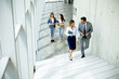 © BGStock72 - Young startup team have a discussion while climbing on  stairs in the office corridor