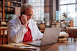 © bernardbodo - Medical professor using cellphone in library.