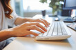 © VisualProduction - Woman's hands typing on a office keyboard with office in the background. Generative AI
