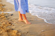 Close up of woman feet walking barefoot on sand beach in sea water. Vacation, travel and freedom concept.