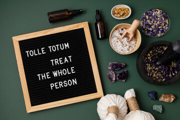 Letter board with text Tolle totum meaning treat the whole person in latin. Naturopatical principle. Botanical blends, herbs, essencial oils for naturopathy. Natural remedy, herbal medicine concept