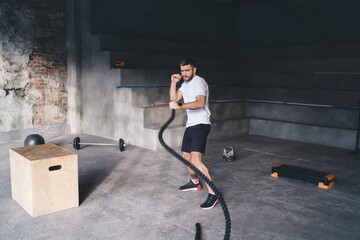 Wall Mural - Sportsman exercising with ropes in gym