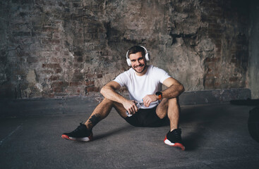 Wall Mural - Young man in headphones with water on floor