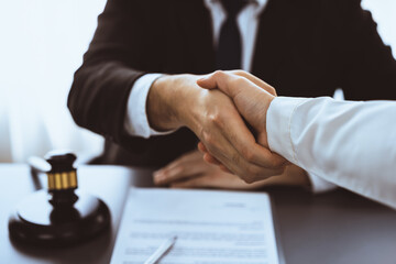 Wall Mural - Closeup lawyer or attorneys colleagues handshake after successful legal discussing on contract agreement for lawsuit to advocate resolves dispute in court ensuring trustworthy partner. Equilibrium