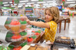 Kid choosing cakes, cupcake muffin. Child buying sweets in supermarket.