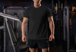 Black t-shirt template on an athlete on the background of the inventory in the gym, quality sportswear for design, print, front view.