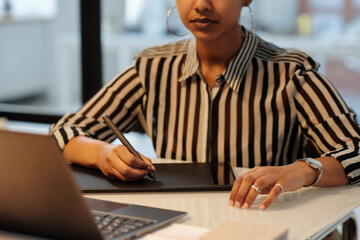 Aufkleber - Focus on hands of young African American female graphic designer with stylus drawing something on touchpad screen in front of laptop