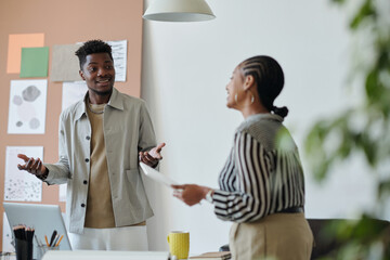 Aufkleber - Focus on smiling young man in casualwear explaining something to female colleague while discussing working points at meeting in office