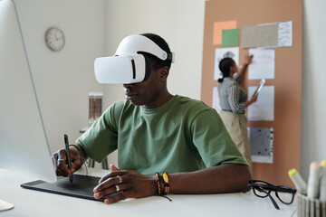 Aufkleber - Young African American male designer with vr headset using touchpad and stylus while sitting by desk and creating new computer games