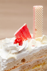 Wall Mural - Close-up of a Delicious Pineapple pastry with a cherry and wafer on top. On a white plate. Front view.