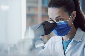 Wall Mural - scientist examining samples under a microscope