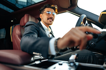 Poster - Young businessman in elegant suit driving luxury car