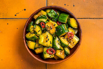 Pai huang gua Chinese Smashed Cucumber salad. Orange background. Top view