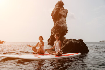 Woman sup yoga. Happy sporty woman practising yoga pilates on paddle sup surfboard. Female stretching doing workout on sea water. Modern individual female hipster outdoor summer sport activity.