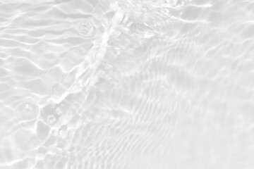 White water with ripples on the surface. Defocus blurred transparent white colored clear calm water surface texture with splashes and bubbles. Water waves with shining pattern texture background.