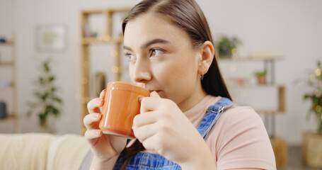 Poster - Relax, thinking and a woman drinking coffee on the sofa for happiness, peace and morning break. Sitting, living room and a girl with a warm beverage, tea drink and relaxing on the couch at home