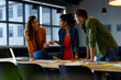 © WavebreakMediaMicro - Happy diverse male and female colleagues with laptop in discussion in casual office meeting