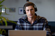 © WavebreakMediaMicro - Caucasian casual businessman making video call using headphones and laptop at desk