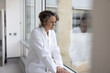 © ReeldealHD images - Exhausted female doctor looking out of the window thinking in a hospital