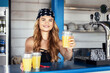 © DanRentea - Hipster girl bartender serving fresh lemonade behind counter at outdoor bar during summer festival