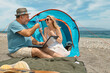 © Caterina Trimarchi - Couple having fun, drinking wine and talking with friends in video call in laptop in picnic near tent on seaside. Vacation summer on the beach in outdoors. Travel, vacation and friendship concept.
