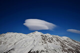 Fototapeta Kwiaty - Panorama of mountain rocky ridge and lenticular cloud