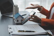 © Sirikarn Rinruesee - Female woman hands holding home model, small miniature white toy house. Mortgage property insurance dream moving home and real estate concept