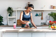 © nenetus - Athletic woman eating a healthy bowl of muesli with fruit in the kitchen at home
