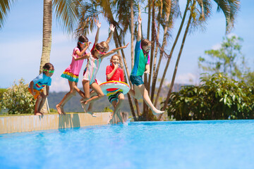 Wall Mural - Kids jump into swimming pool. Summer water fun.