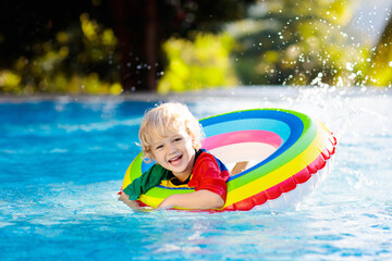 Wall Mural - Child in swimming pool on toy ring. Kids swim.