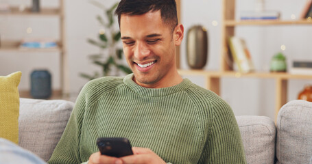 Wall Mural - Laughing, phone and relax with man on sofa for social media, internet and text message. Happy, smile and technology with male in living room at home for communication, connection and digital app