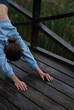 © Veronica Holubnycha - Girl with athletic body in blue gym suit is doing yoga exercises in cloudy rainy weather.
