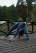 © Veronica Holubnycha - Girl in blue gym suit is doing exercises in the park in cloudy rainy weather.
