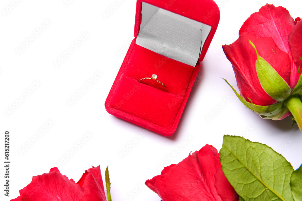 Box with engagement ring and roses on white background, closeup