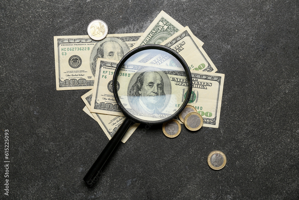 Magnifier with one hundred dollars on grunge black background