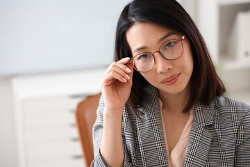 Wall Mural - Beautiful Asian businesswoman in stylish eyeglasses in office, closeup