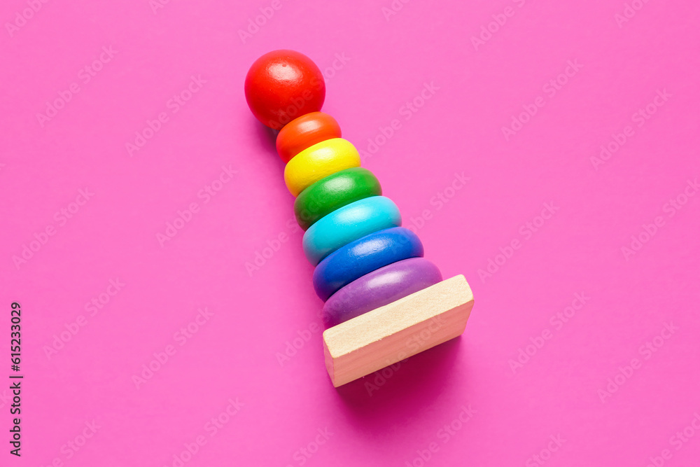 Wooden colorful toy pyramid on pink background. Children's Day celebration
