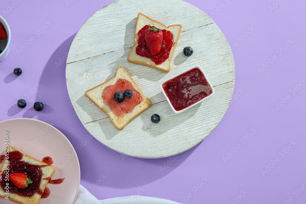 Light wooden board with delicious toasts and jam on color background