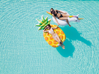 Wall Mural - lgbt couple drinking and hugging each other in swimming pool, view from above