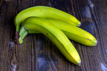 Green unripe bananas on the table