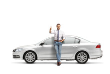 Full Length Portrait Of A Man Leaning On A Silver Car And Gesturing Thumbs Up