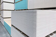 The large stack of Special gypsum board with enhanced sound insulation Plasterboard. Panel Type A for indoor concrete walls prepared for construction in hardware stores.