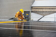 Engineer checks the operation of the solar cell system installed on the factory roof, engineers, technicians use computer to check the operation of solar cell panel installed on the industrial roof.